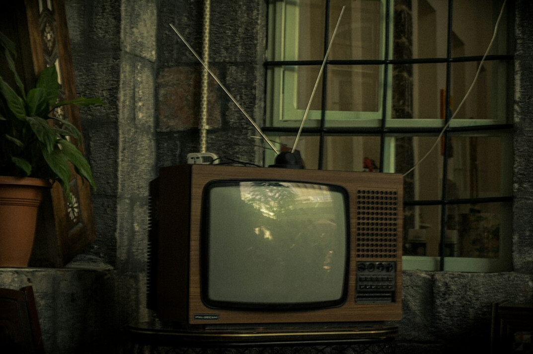 Vintage analog television displaying static noise in a dim room